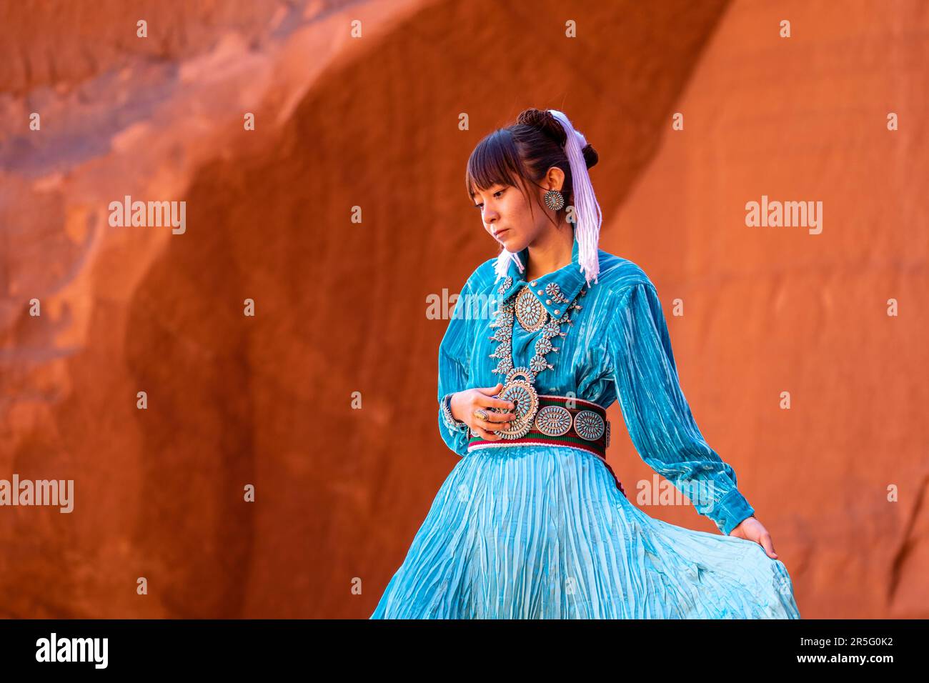 Junge indianische Navajo-Frau am Big Hogan Arch im Monument Valley Navajo Tribal Park, Arizona, USA Stockfoto