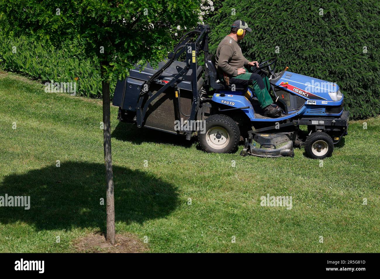 Düsseldorf, Deutschland , 01.06.2023 ein Gartenarbeiter mäht die Grünfläche einer Wohnanlage mit einem Mäh Traktor der Firma Iseki in Düsseldorf - Mörsenbroich Foto : Norbert Schmidt Stockfoto