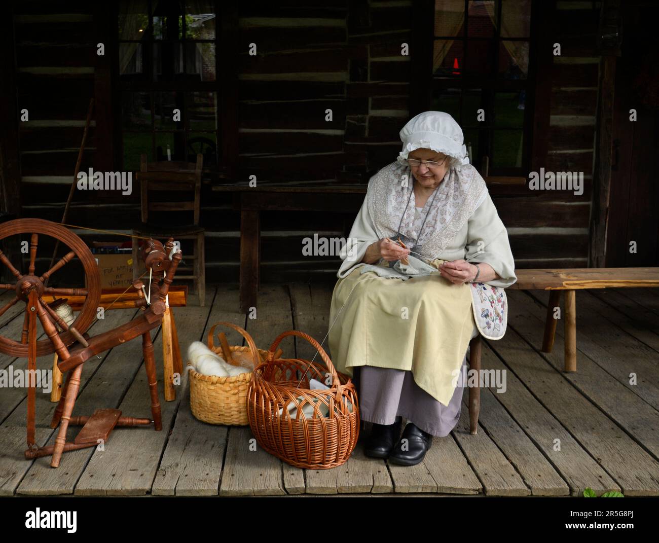 Ein Pionierreenactor aus dem 19. Jahrhundert demonstriert, wie Frauen in der Vergangenheit bei einer Veranstaltung in Abingdon, Virginia, Handschuhe und andere Gegenstände gestrickt haben. Stockfoto