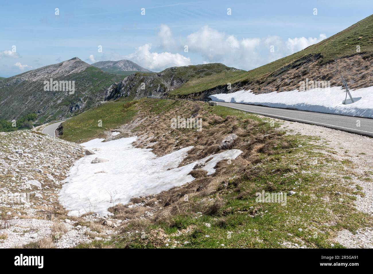 Berglandschaft im Apennine Range in der Nähe von Monte Terminillo im Mai in Mittelitalien, Europa, mit Schnee am Straßenrand Stockfoto