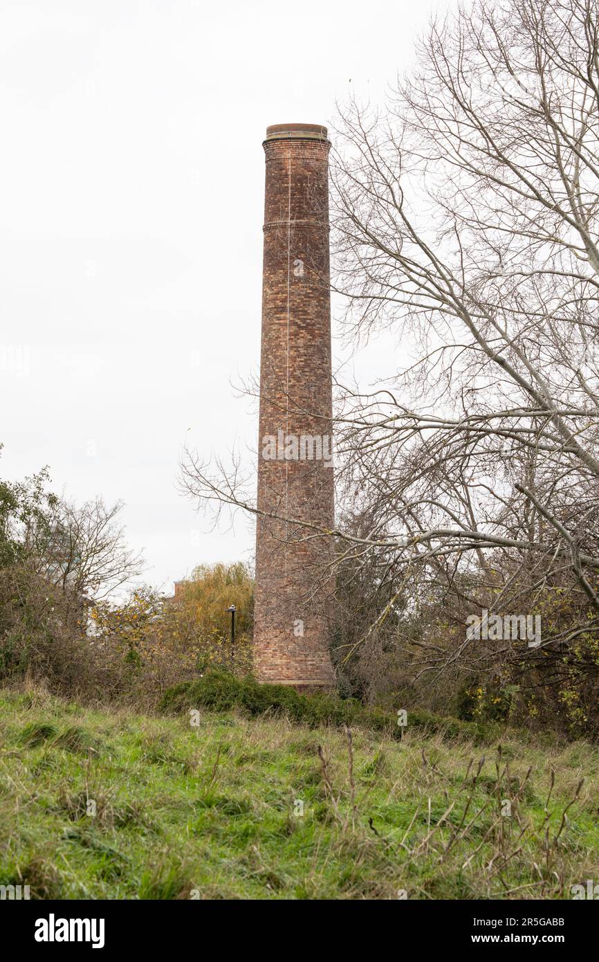 London, Vereinigtes Königreich - November 23 2020: Ein stillgelegter Ziegelschornstein auf der Isle of Dogs im Osten Londons auf einem Feld. Stockfoto