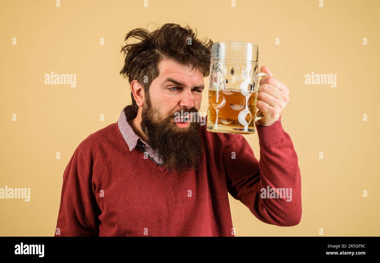 Oktoberfest. Ein bärtiger Mann trinkt Bier vom Fass. Betrunkener, bärtiger Mann mit einer Tasse Bier. Alkohol, Brauerei. Schlechte Angewohnheiten. Alkoholismus. Bier Stockfoto