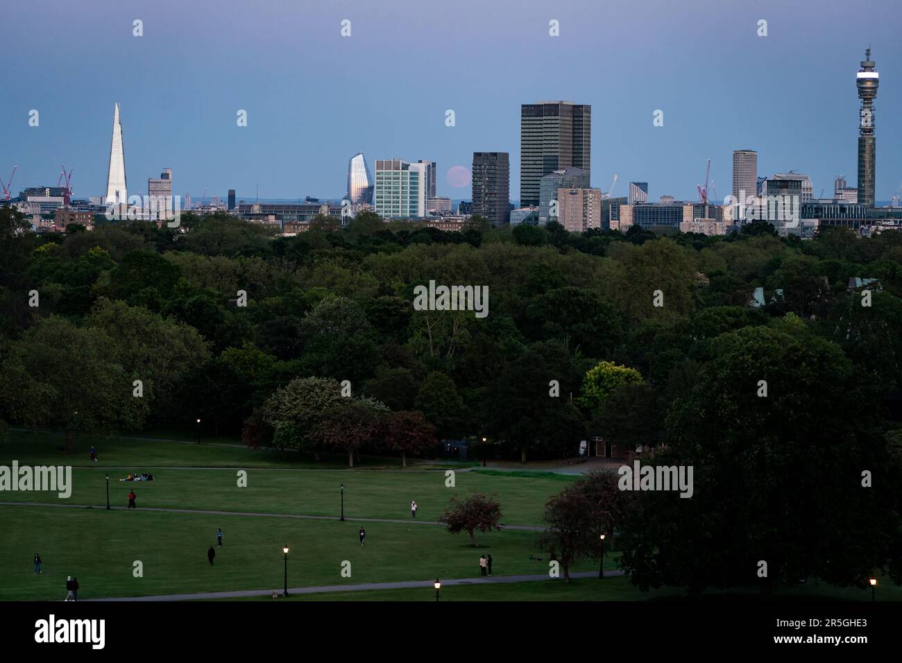 Der Blick vom Primrose Hill in London auf den Vollmond, auch bekannt als der Erdbeermond, der über der City of London aufsteigt. Foto: Samstag, 3. Juni 2023. Stockfoto