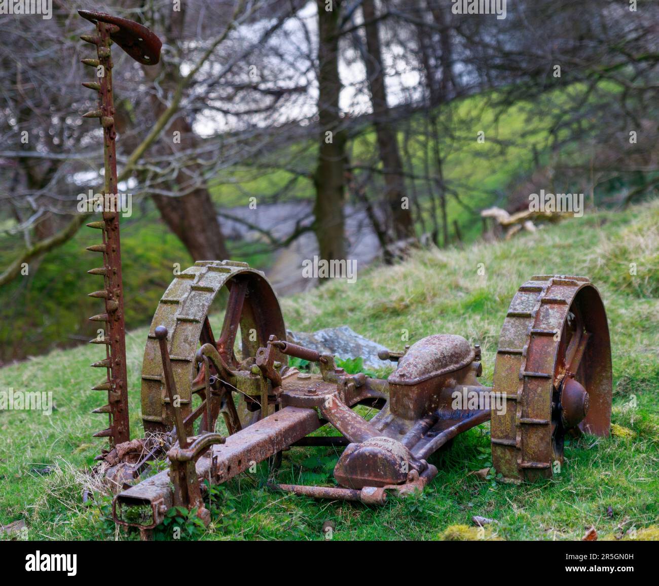 Eine alte mechanische Erntemaschine, die hinter einen Traktor gezogen worden wäre, um Erntegut zu ernten. Stockfoto
