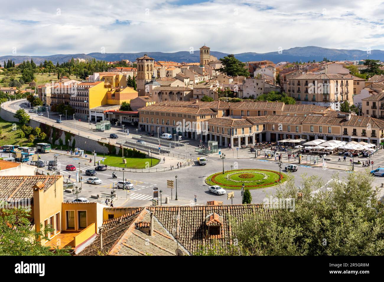 Segovia, Spanien, 03.10.21. Segovia Stadtbild mit Straße, grünem Kreisverkehr, vorbeifahrenden Autos und engen Steinstraßen, mittelalterliche Architektur. Stockfoto