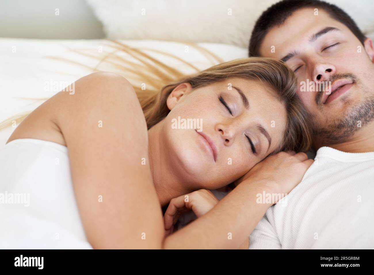 Gemeinsam träumen. Attraktives, junges Paar, das im Bett schläft. Stockfoto