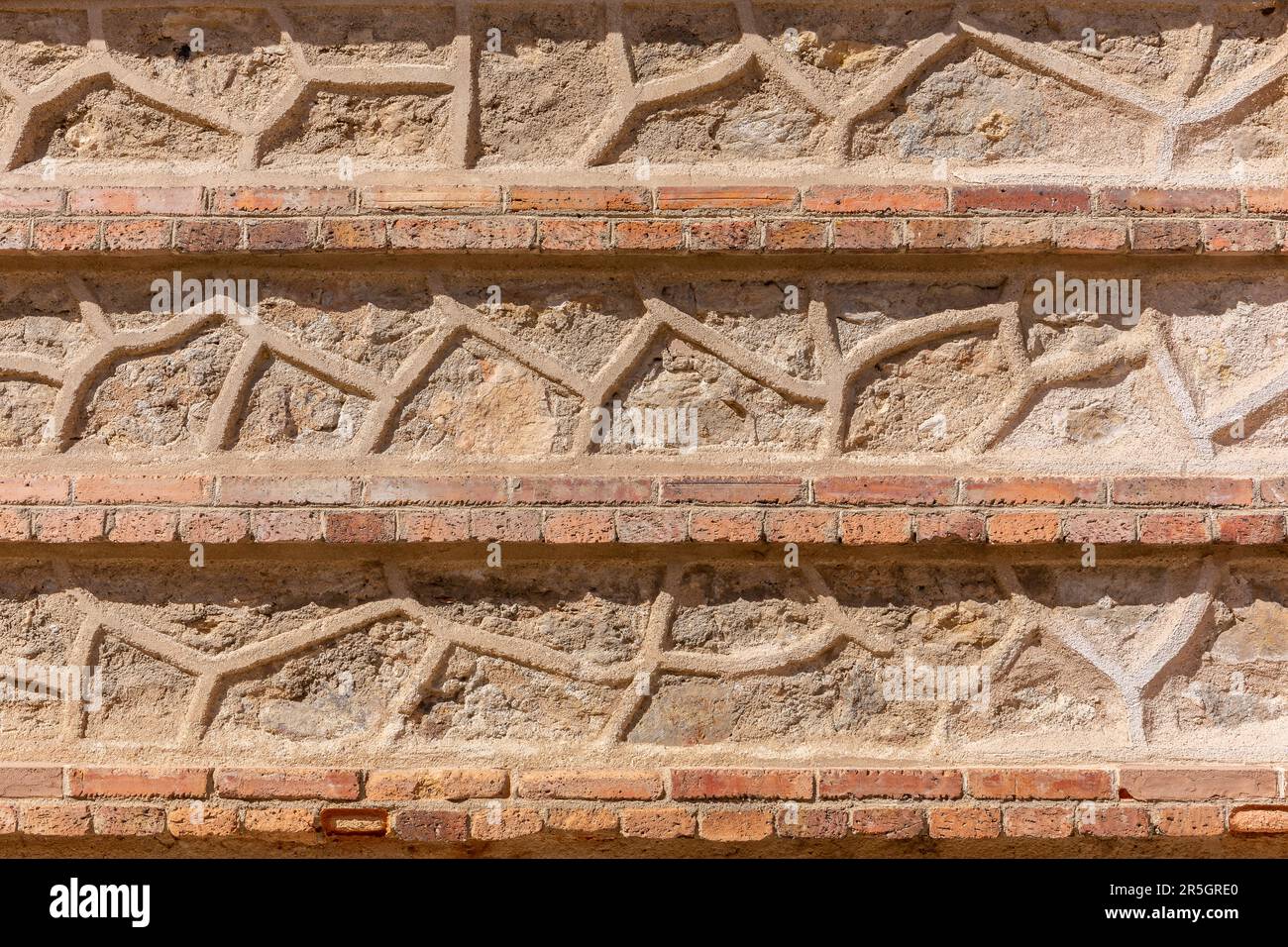 Mittelalterliche Fassade aus Stein und Ziegelbraun und Orange in Segovia, Spanien, mit geometrischen Formen und Linien. Stockfoto