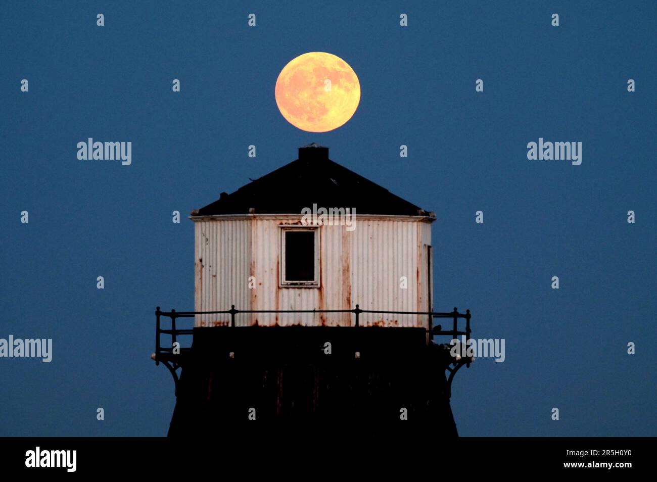 Dovercourt Essex, Großbritannien. 3. Juni 2023. Der Strawberry Moon erhebt sich hinter dem Dovercourt Lower Lighthouse in Essex. Der Vollmond im Juni wird der Erdbeermond genannt, nicht wegen seiner Farbe, sondern weil die Algonquin-Stämme in Nordamerika ihn benannt haben, weil er während der Erdbeererntezeit auftrat. Kredit: MARTIN DALTON/Alamy Live News Stockfoto