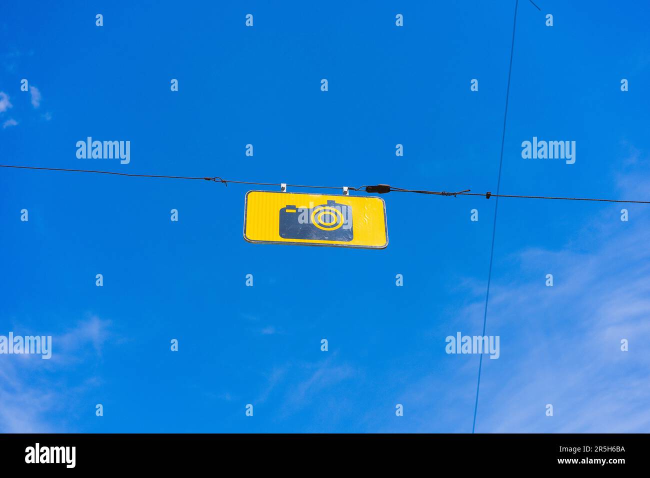Ein Straßenschild mit dem Text „Fotosteuerung“, eine schwarze Kamera auf einem gelben Rechteck mit blauem Himmel auf dem Hintergrund. Stockfoto