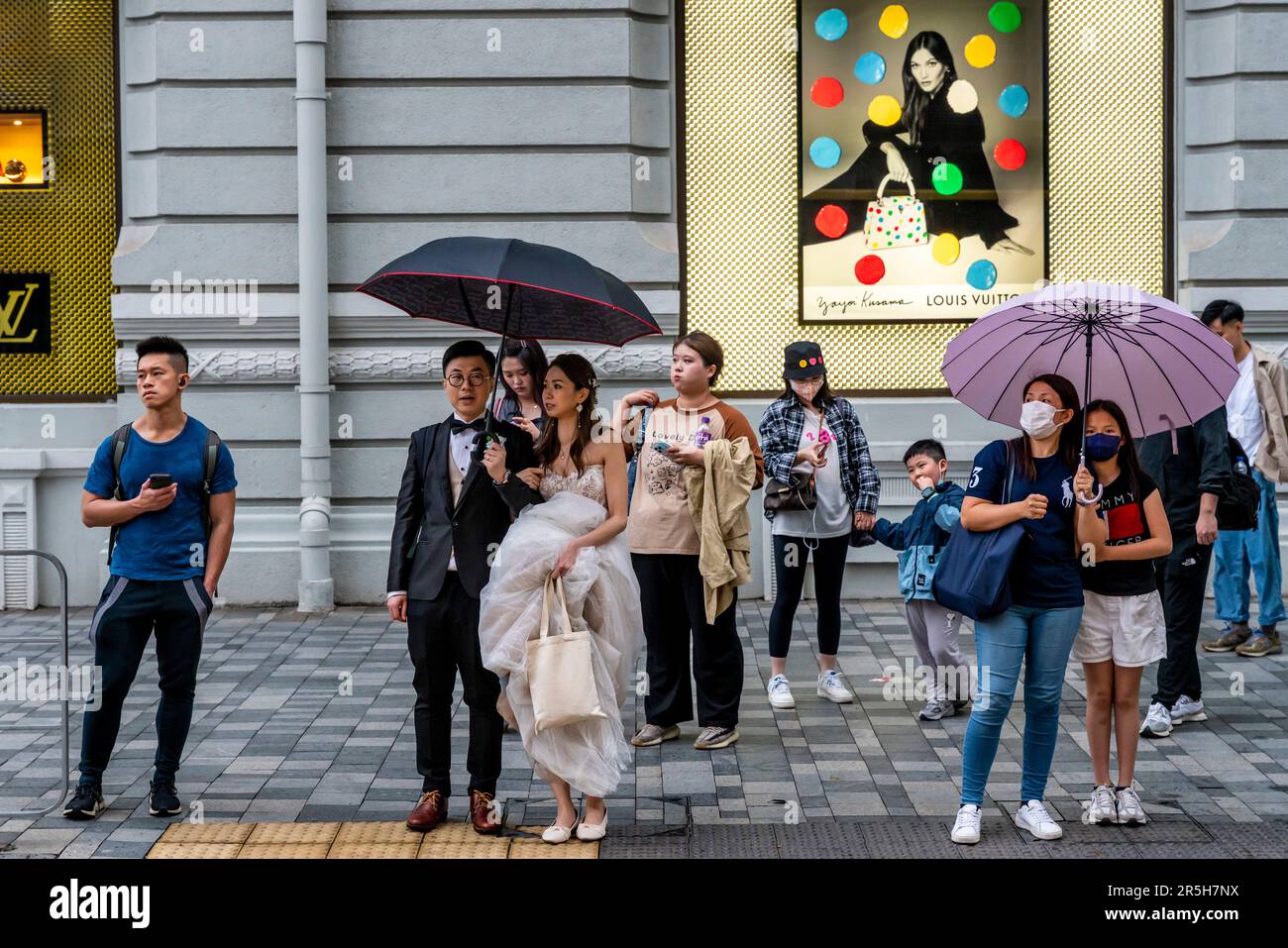 Ein frisch verheiratetes Paar wartet auf Cross the Street, Kowloon, Hongkong, China. Stockfoto