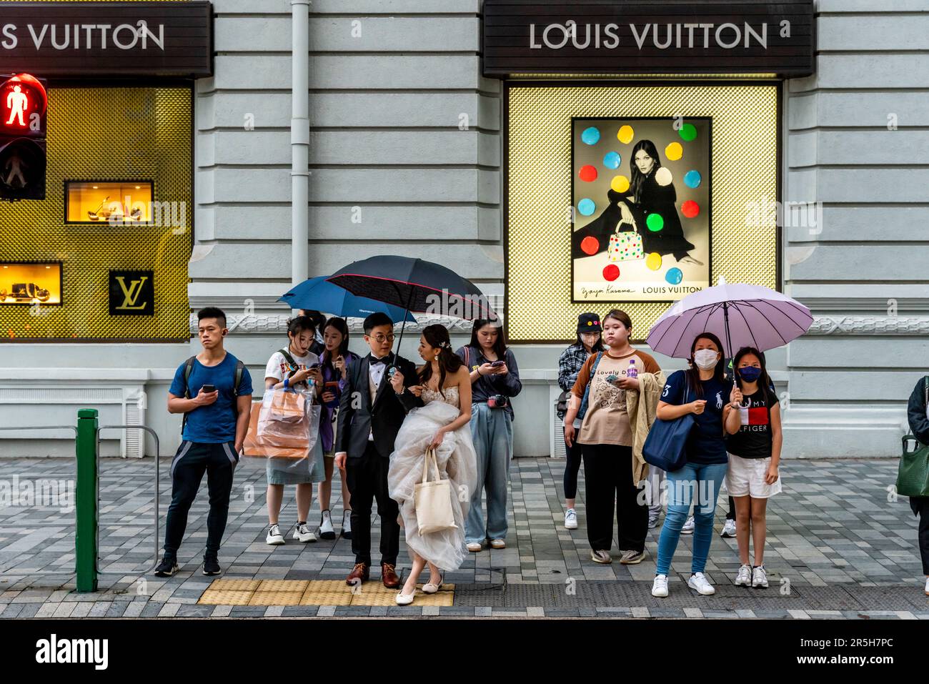 Ein frisch verheiratetes Paar wartet auf Cross the Street, Kowloon, Hongkong, China. Stockfoto