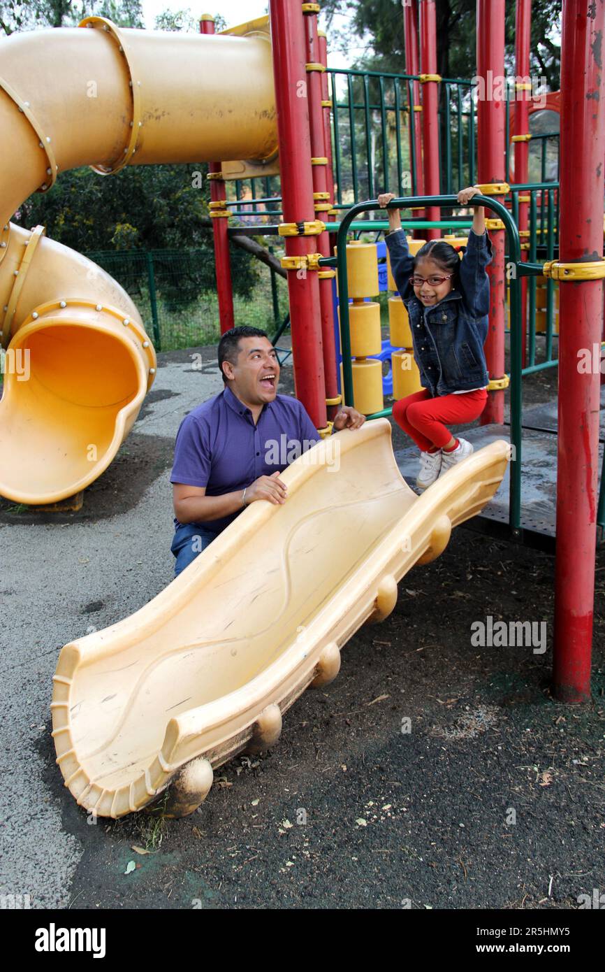 Geschiedener alleinerziehender Vater und 4-jährige Tochter Latino-Brünette spielen auf dem Spielplatz im Freien und verbringen Zeit miteinander – ohne Technologie Stockfoto
