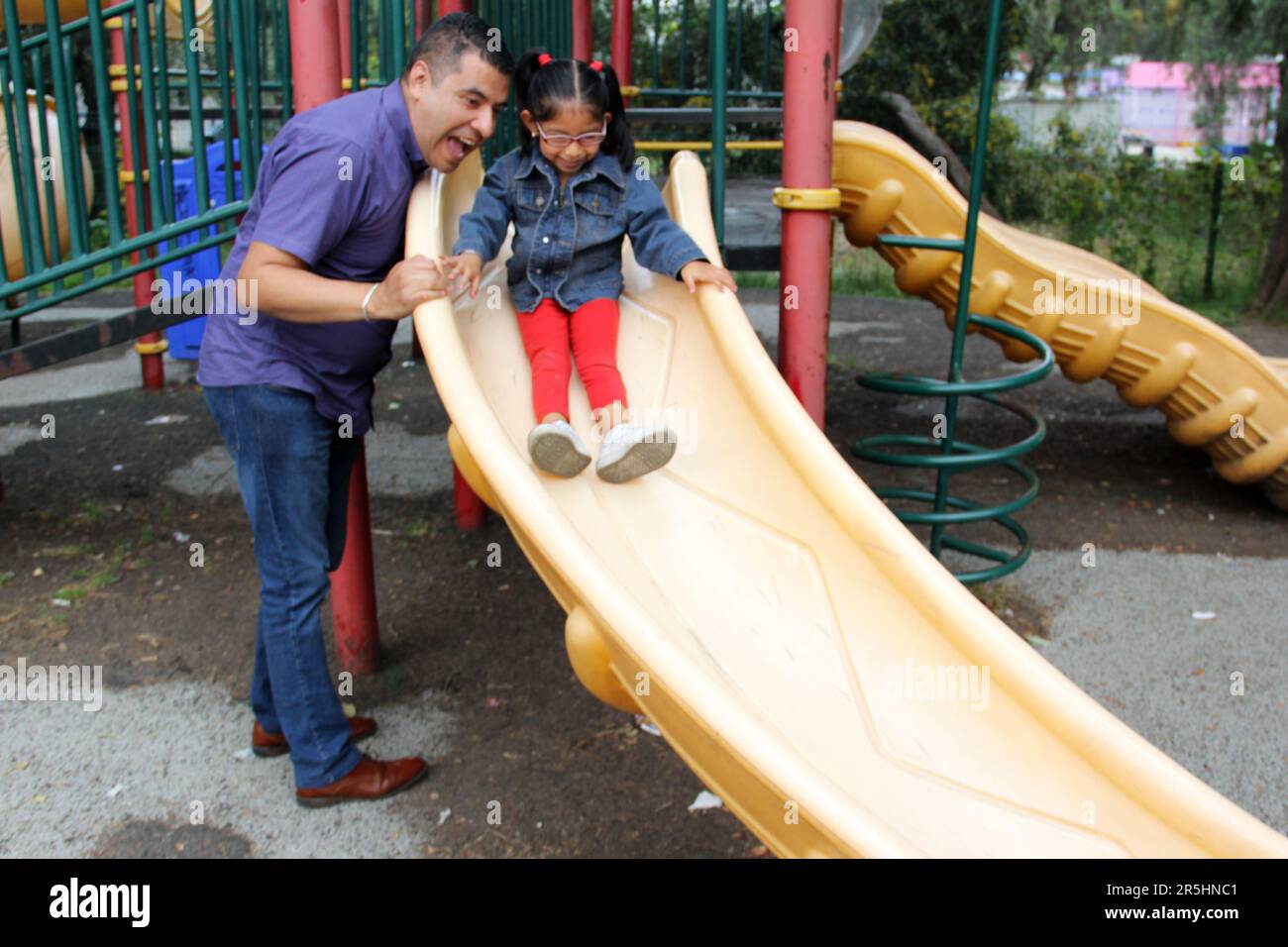 Geschiedener alleinerziehender Vater und 4-jährige Tochter Latino-Brünette spielen auf dem Spielplatz im Freien und verbringen Zeit miteinander – ohne Technologie Stockfoto