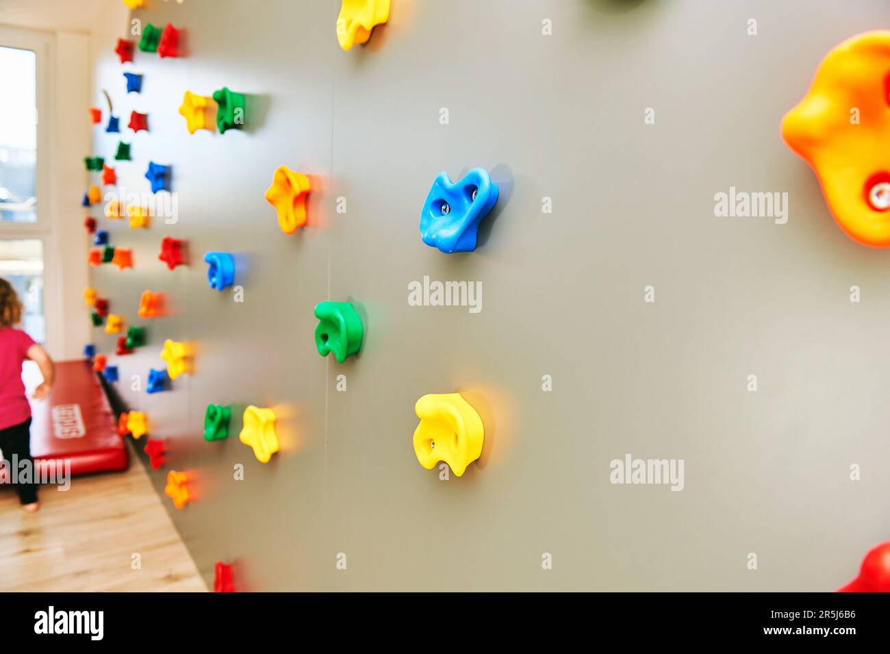 Wand mit Klettergriffen in Kinderbetreuung oder Kindergarten, Aktivität für Kleinkinder Stockfoto