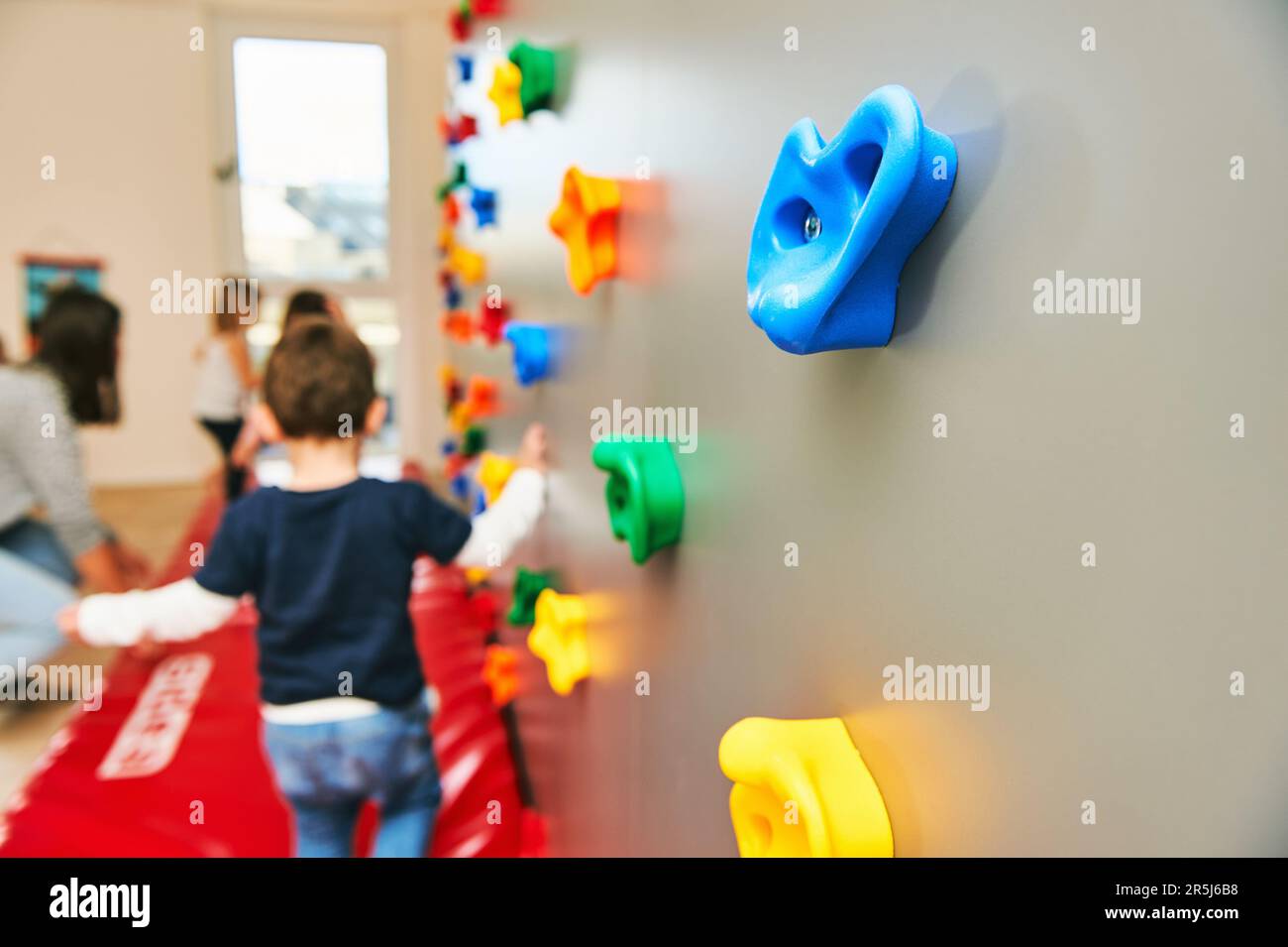 Wand mit Klettergriffen in Kinderbetreuung oder Kindergarten, Aktivität für Kleinkinder Stockfoto