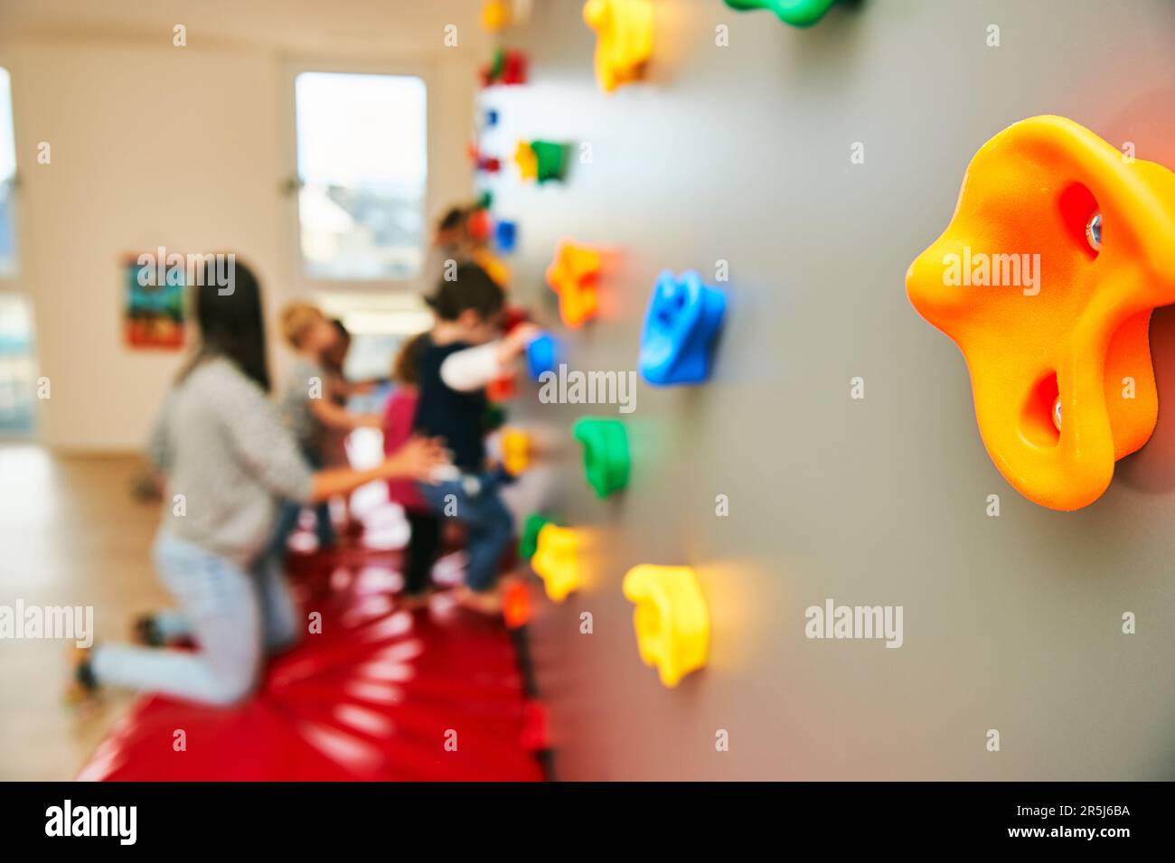 Wand mit Klettergriffen in Kinderbetreuung oder Kindergarten, Aktivität für Kleinkinder Stockfoto