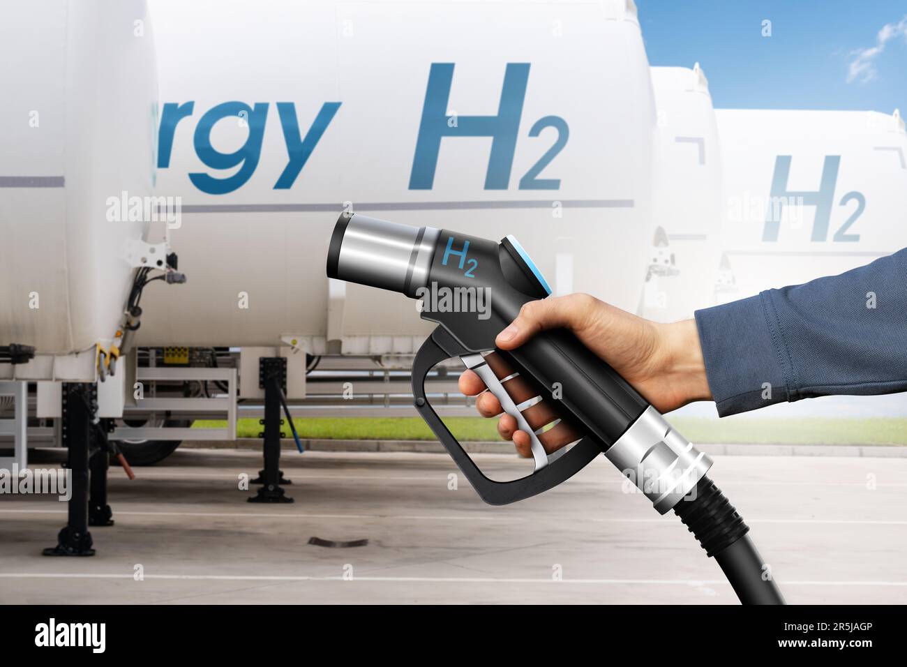 Hand mit Wasserstofftankdüse auf einem Hintergrund von Wasserstofftankanhängern. Konzept „sauberer Kraftstoff“ Stockfoto