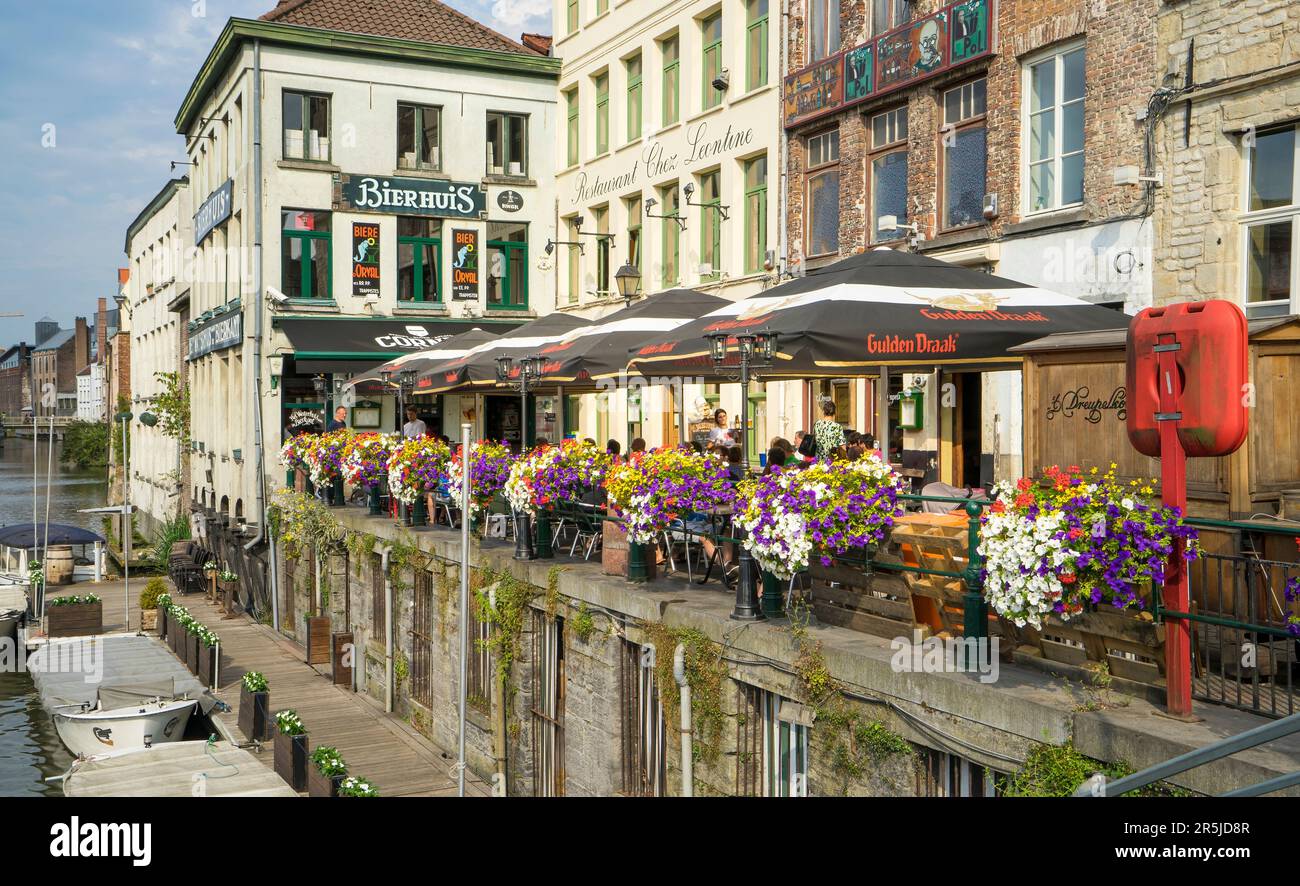 Blick auf eine schöne Ecke mit Terrasse einer Bar am Flussufer in der belgischen Stadt Gent. Das Hotel ist von Touristen sehr frequentiert. Stockfoto