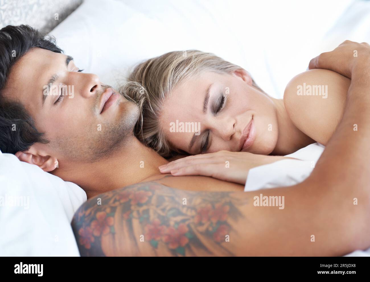 Der beste Ort der Welt. Eine junge Frau, die im Arm ihres Freundes schläft. Stockfoto