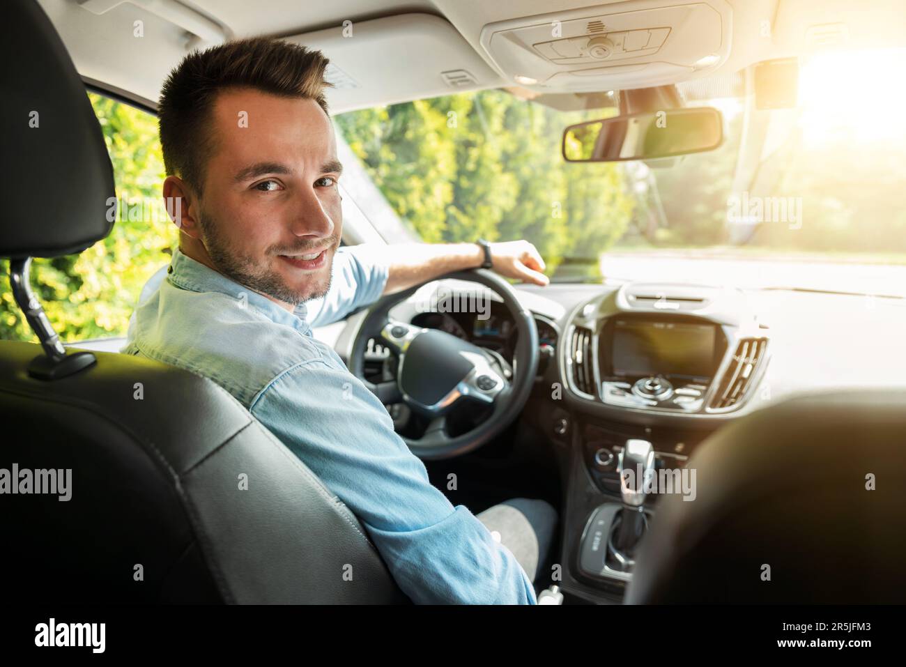 Junger männlicher Fahrer am Steuer. Taxifahrer Stockfoto