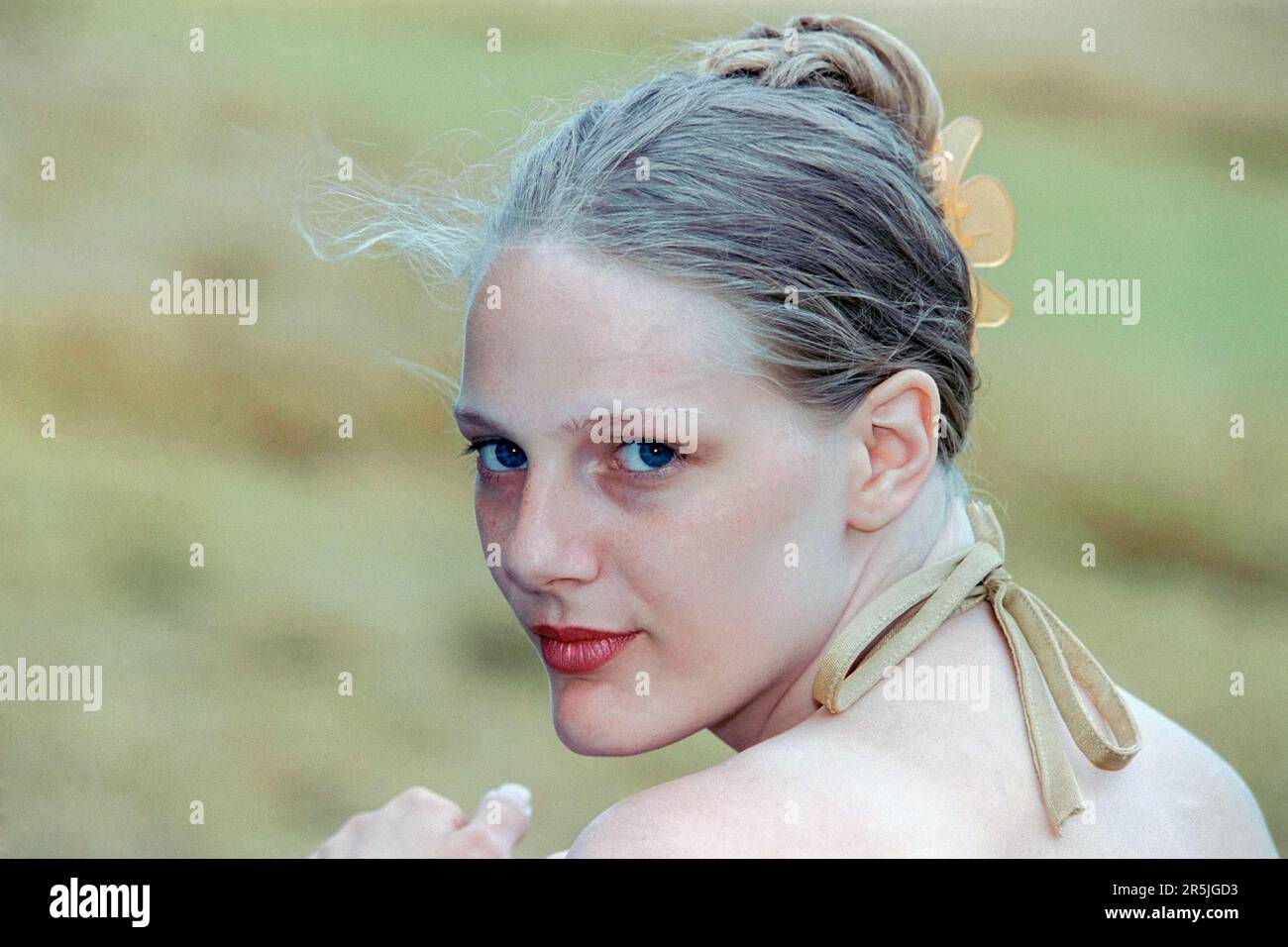 Junge, schlanke, blonde Frau, Anfang 20s, die für ein Porträt in Field 1990er posiert Stockfoto