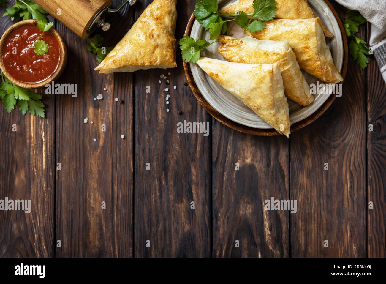 Asiatisches Essen. Vegetarische samsa (Samosas) mit Tomatensoße auf einem Holztisch. Beliebt in Indonesien als Risoles Sayur. Blick von oben. Speicherplatz kopieren. Stockfoto