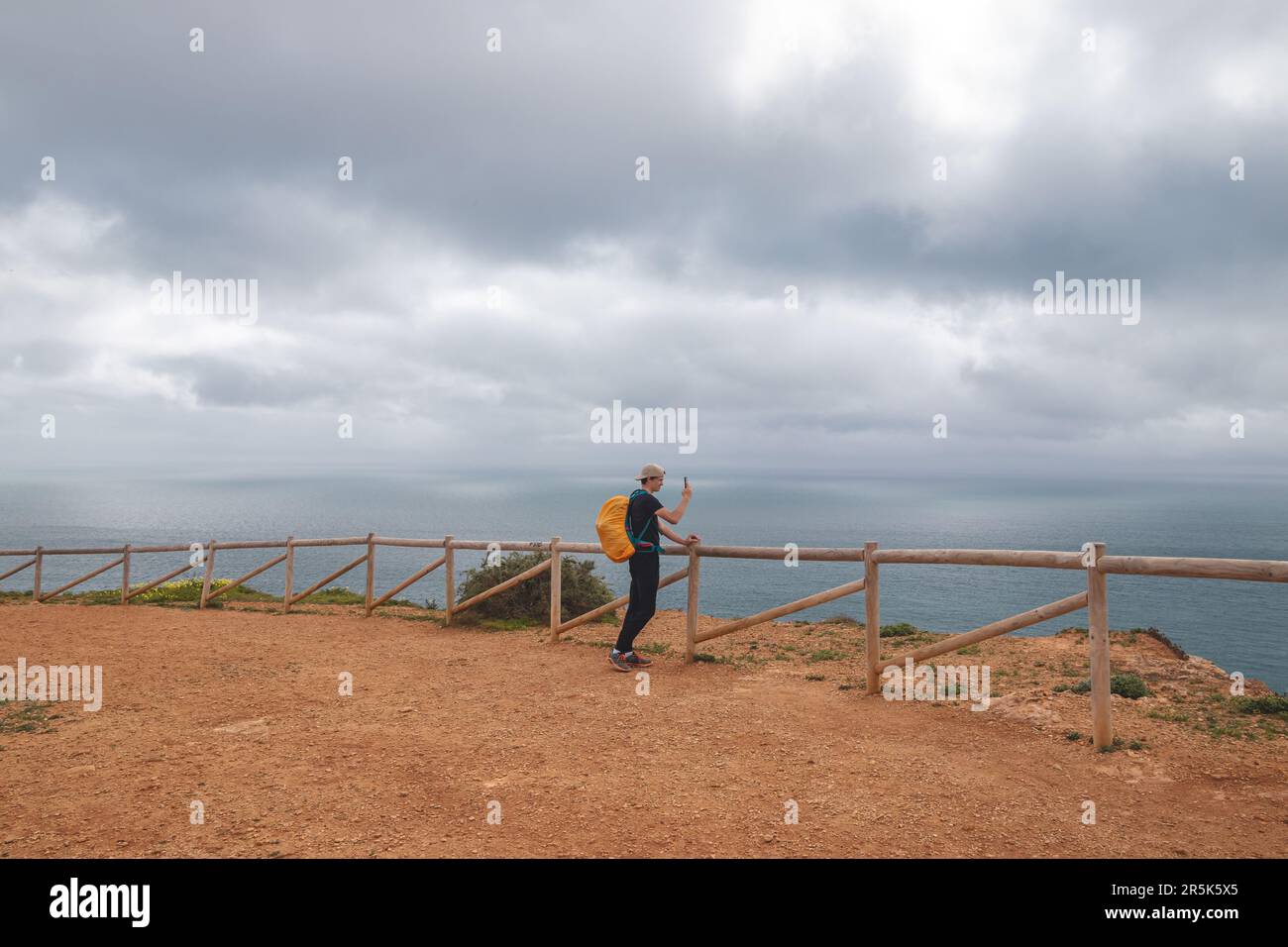 Der Reisende macht ein Foto mit seinem Mobiltelefon auf dem Gipfel des Atalaia Hügels mit Blick auf die Stadt Luz und die Strände des Atlantischen Ozeans in der Alga Stockfoto