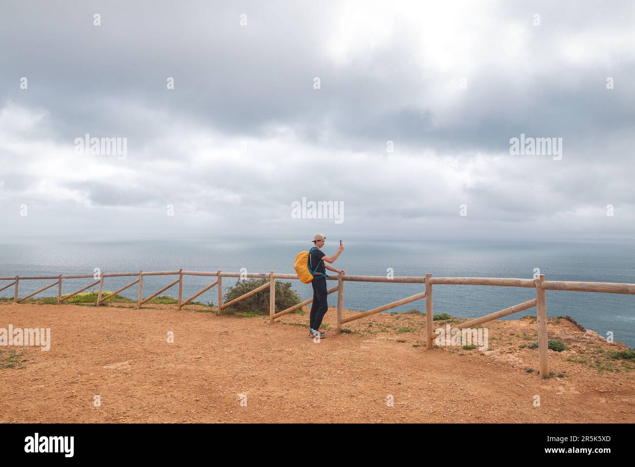 Der Reisende macht ein Foto mit seinem Mobiltelefon auf dem Gipfel des Atalaia Hügels mit Blick auf die Stadt Luz und die Strände des Atlantischen Ozeans in der Alga Stockfoto