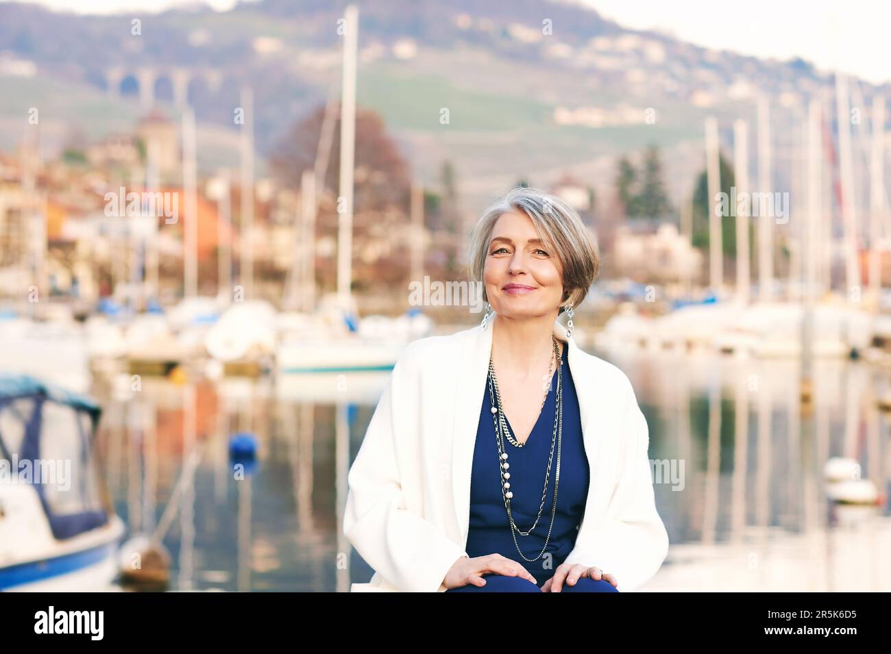 Außenporträt einer mittelalterlichen Frau, die im kleinen Seehafen ruht Stockfoto