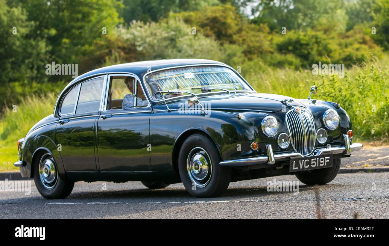 Stony Stratford, Großbritannien - Juni 4. 2023: Grüner JAGUAR MK II Klassiker aus dem Jahr 1968, der auf einer englischen Landstraße fährt. Stockfoto