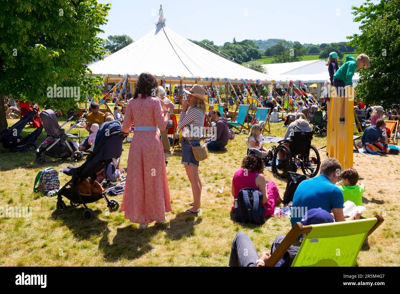 Besucher Leser Familien Familien entspannen sich auf dem Rasen in der Sonne auf dem Hay Festival 2023, Hay on Wye Wales UK KATHY DEWITT Stockfoto