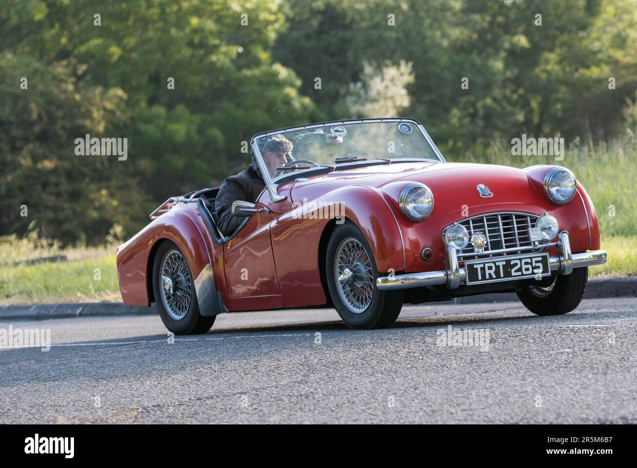 Stony Stratford, Großbritannien - Juni 4. 2023: 1956 Red TRIUMPH TR3 Oldtimer, das auf einer englischen Landstraße fährt. Stockfoto