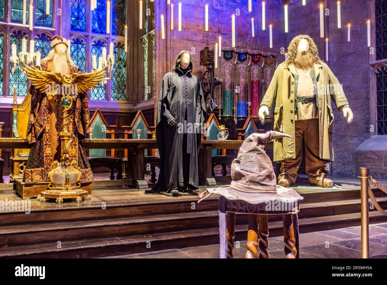 Snape-, Dumbledore- und Hagrid-Kostüme, getragen von Schaufensterpuppen mit dem Sortierhut an der Vorderseite der Großen Halle auf der Harry Potter Studio Tour. Stockfoto