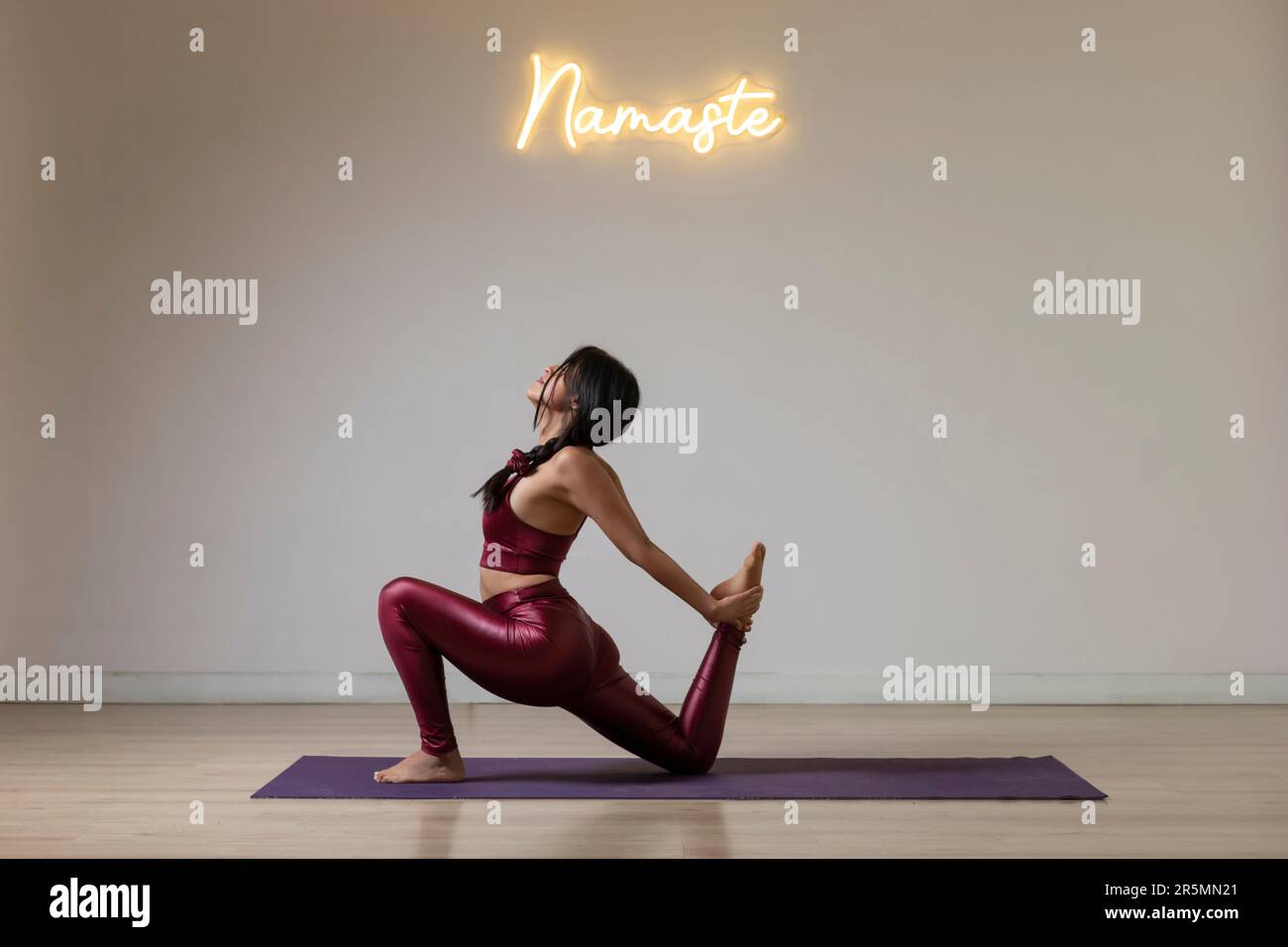 Junge Mexikanerin, die Yoga praktiziert und am Boden posiert Stockfoto