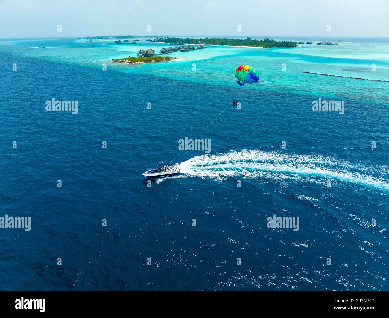 Luftaufnahme, Malediven, North Male Atoll, Paraglider auf Paradise Island mit Wasser-Bungalows Stockfoto