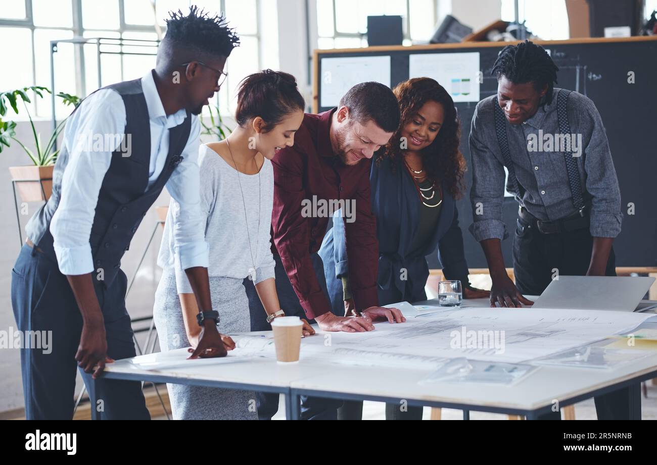 Lasst uns alle losen Enden aufräumen. Ein Team von Profis, das an Entwürfen in einem Büro arbeitet. Stockfoto