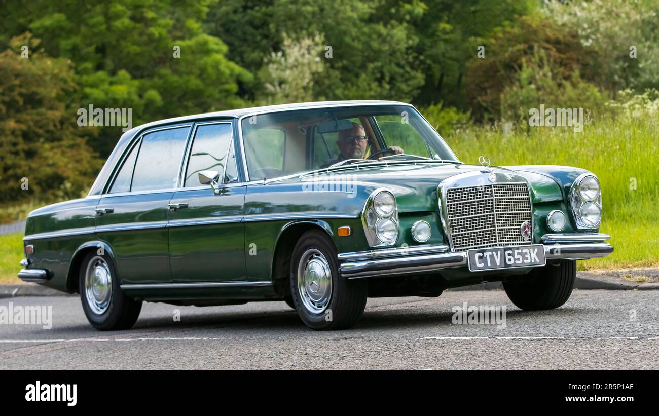 Stony Stratford, Großbritannien - Juni 4. 2023: 1972 grüner MERCEDES 280 SEL-Klassiker, der auf einer englischen Landstraße fährt. Stockfoto