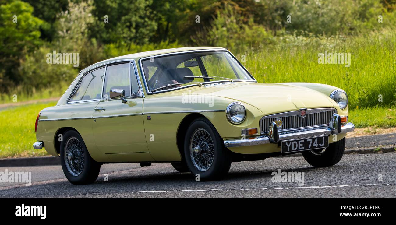 Stony Stratford, Großbritannien - Juni 4. 2023: 1970 gelber MG B GT-Klassiker, der auf einer englischen Landstraße fährt. Stockfoto