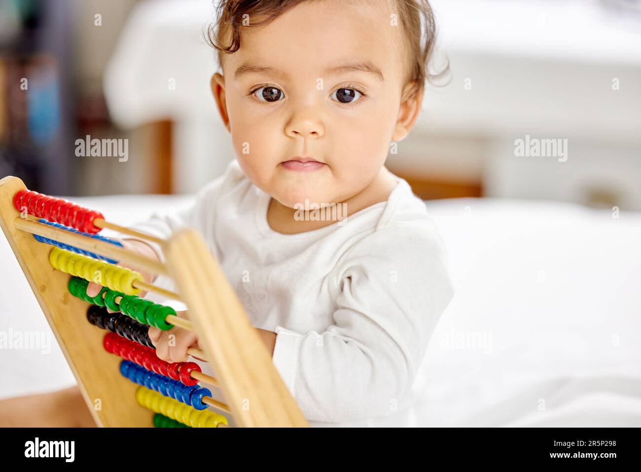 Abacus, das Schlafzimmer und das Baby spielen mit dem Spielzeug, um das Lernen, die Entwicklung und die motorischen Fähigkeiten des Kindes zu fördern. Familienhaus, Neugeborenes und Gesicht eines liebenswerten Kindes mit Stockfoto
