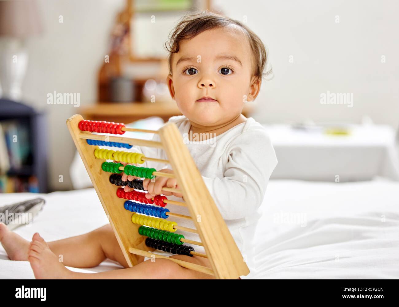 Abacus, Bett und Porträt des Babys mit Spielzeug für Lernspaß, kindliche Entwicklung und motorische Fähigkeiten. Familienhaus, Neugeborenes und Gesicht eines liebenswerten Kindes mit Stockfoto