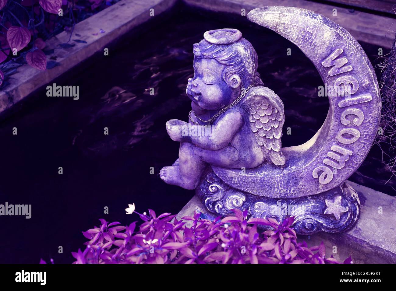 Surreal Pop Art-Stil Purple Sculpture of an Angel Sitting on Crescent Moon in the Garden Stockfoto