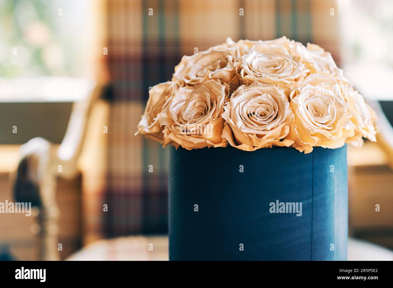 Blumen in einer runden Geschenkbox, Strauß goldener Rosen in einer Pappkiste Stockfoto