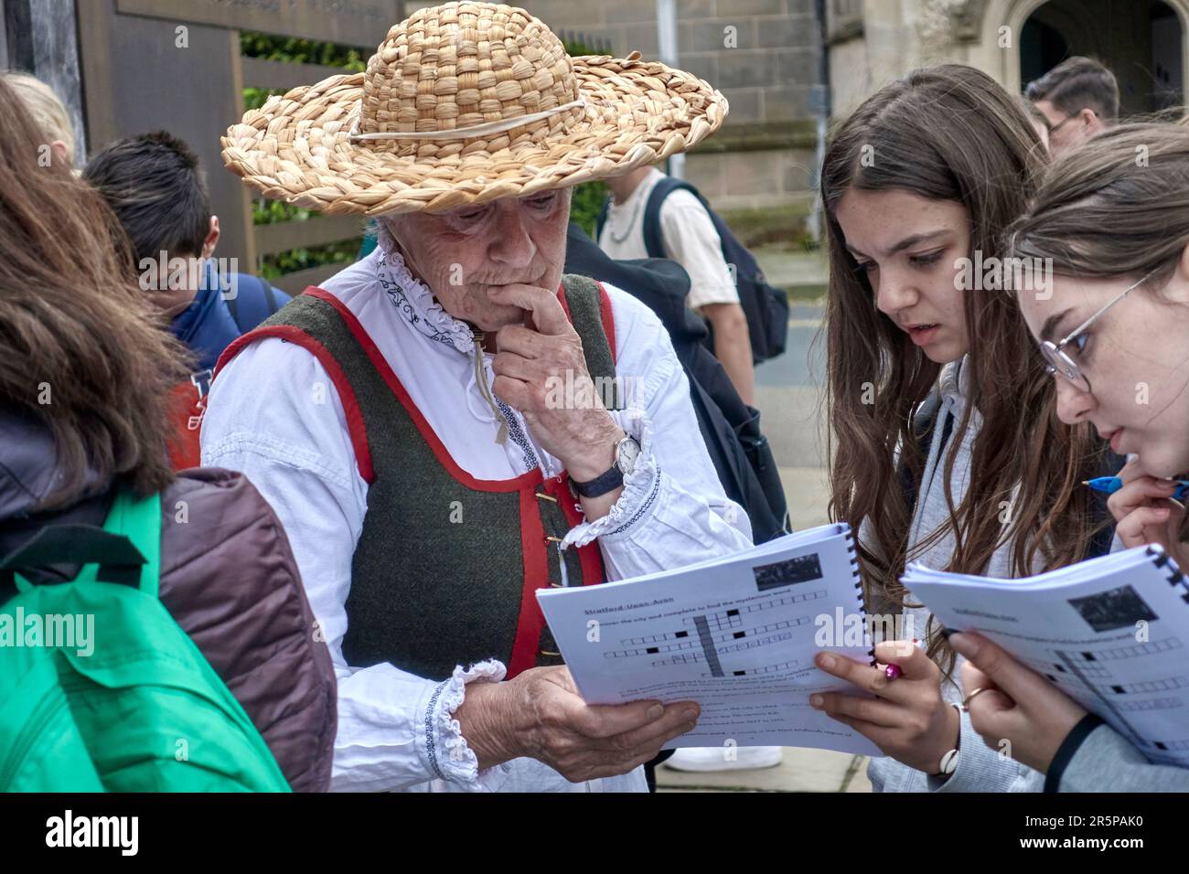 Reiseleiter UK. Frau in traditionellem Tudor-Kostüm mit ausländischen Schülern auf einem informationsgeschichtlichen Faktenfindungskurs. Stratford auf Avon England Stockfoto