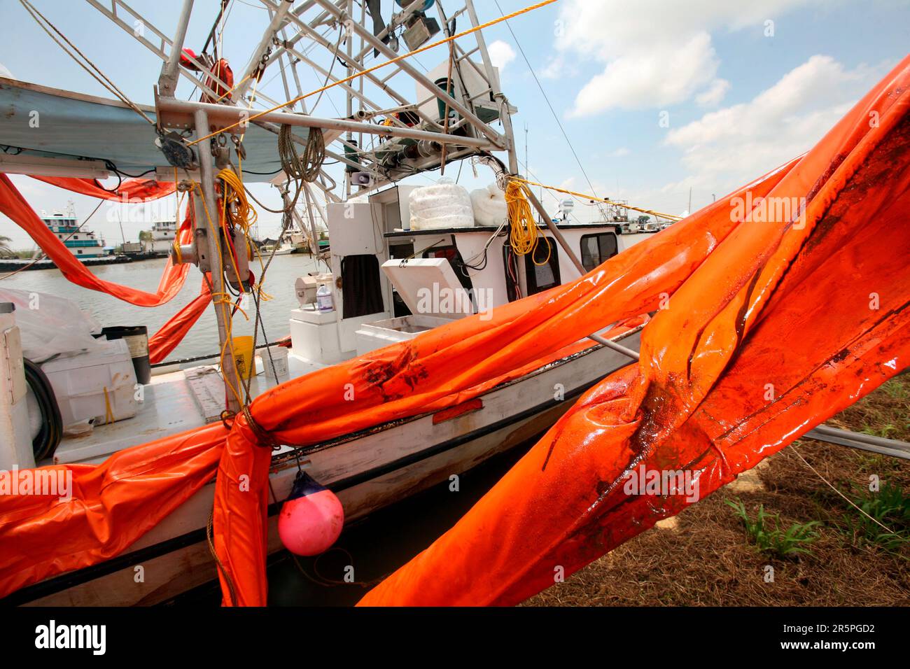 Ein schmutziger Boom mit Ölrückständen hängt an einem Garnelenboot in einem Hafen in Venedig, Louisiana. Stockfoto