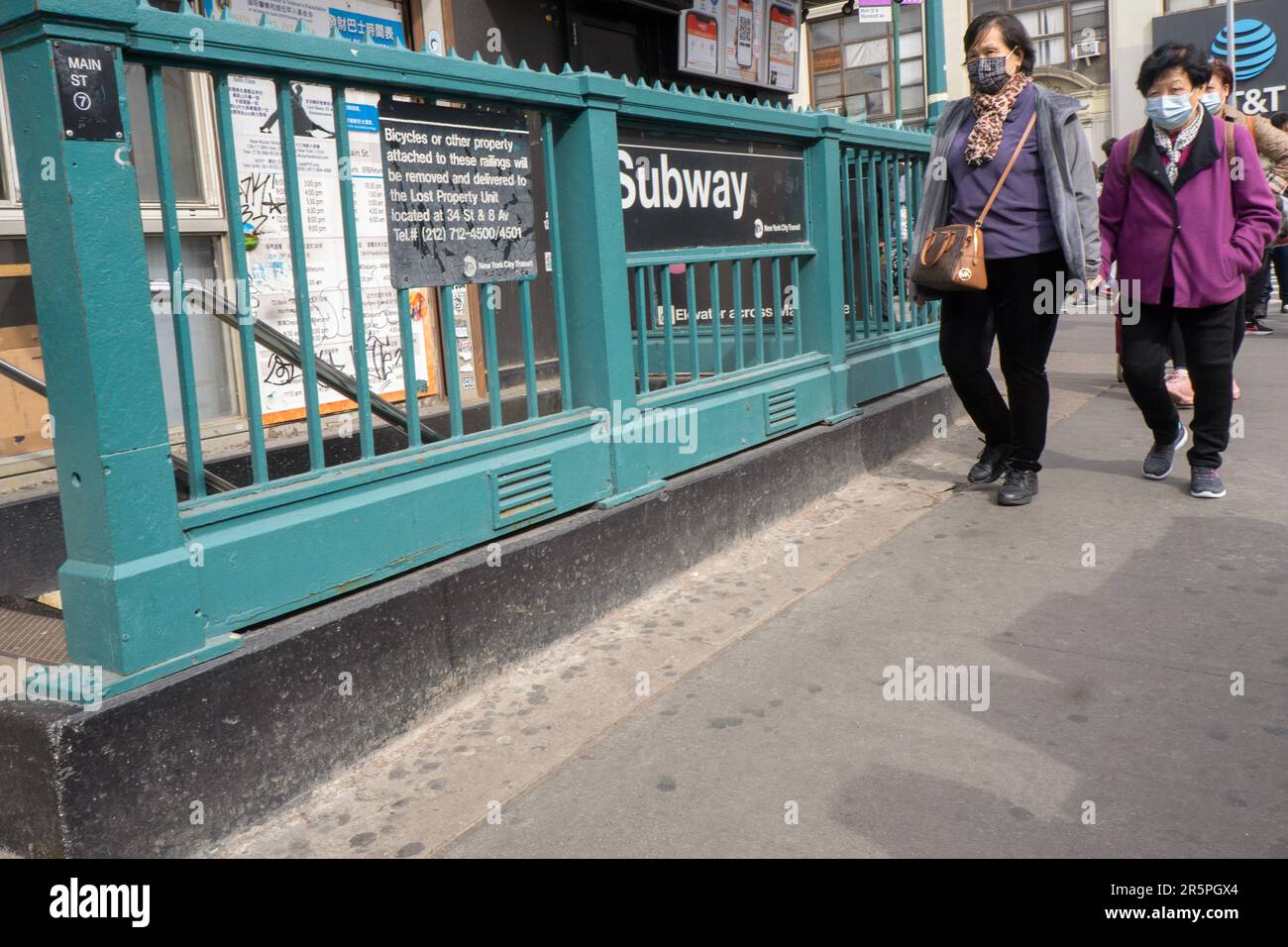 Asiatisch-amerikanische Frauen mittleren Alters, wahrscheinlich ein chinesischer Spaziergang auf der Roosevelt Avenue in der Nähe des Eingangs zur U-Bahnstation Nr. 7. Stockfoto
