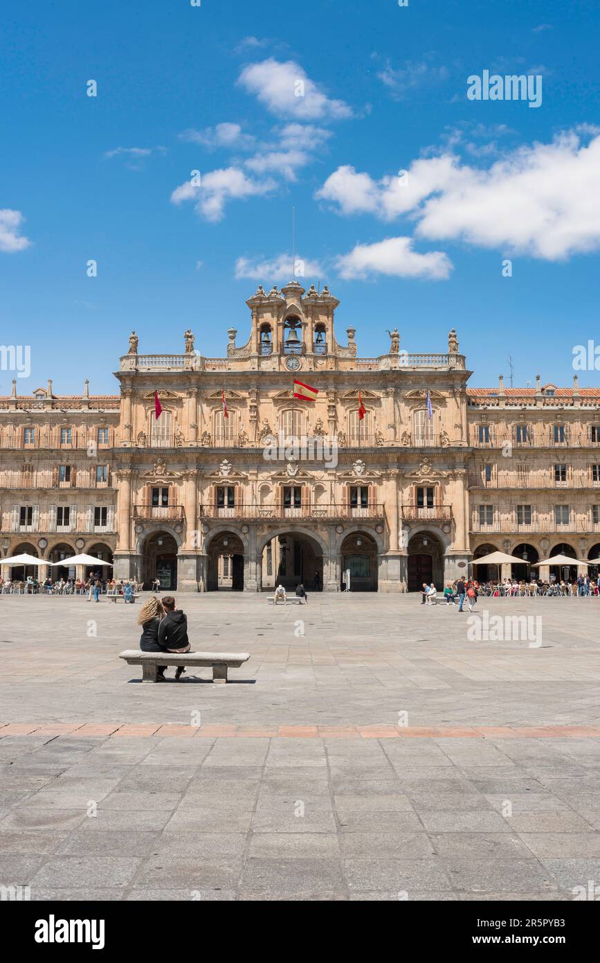 Urlaubspaar, Rückansicht im Sommer eines jungen Paares mit Blick auf das große Rathaus auf der barocken Plaza Mayor in der Stadt Salamanca, Spanien Stockfoto