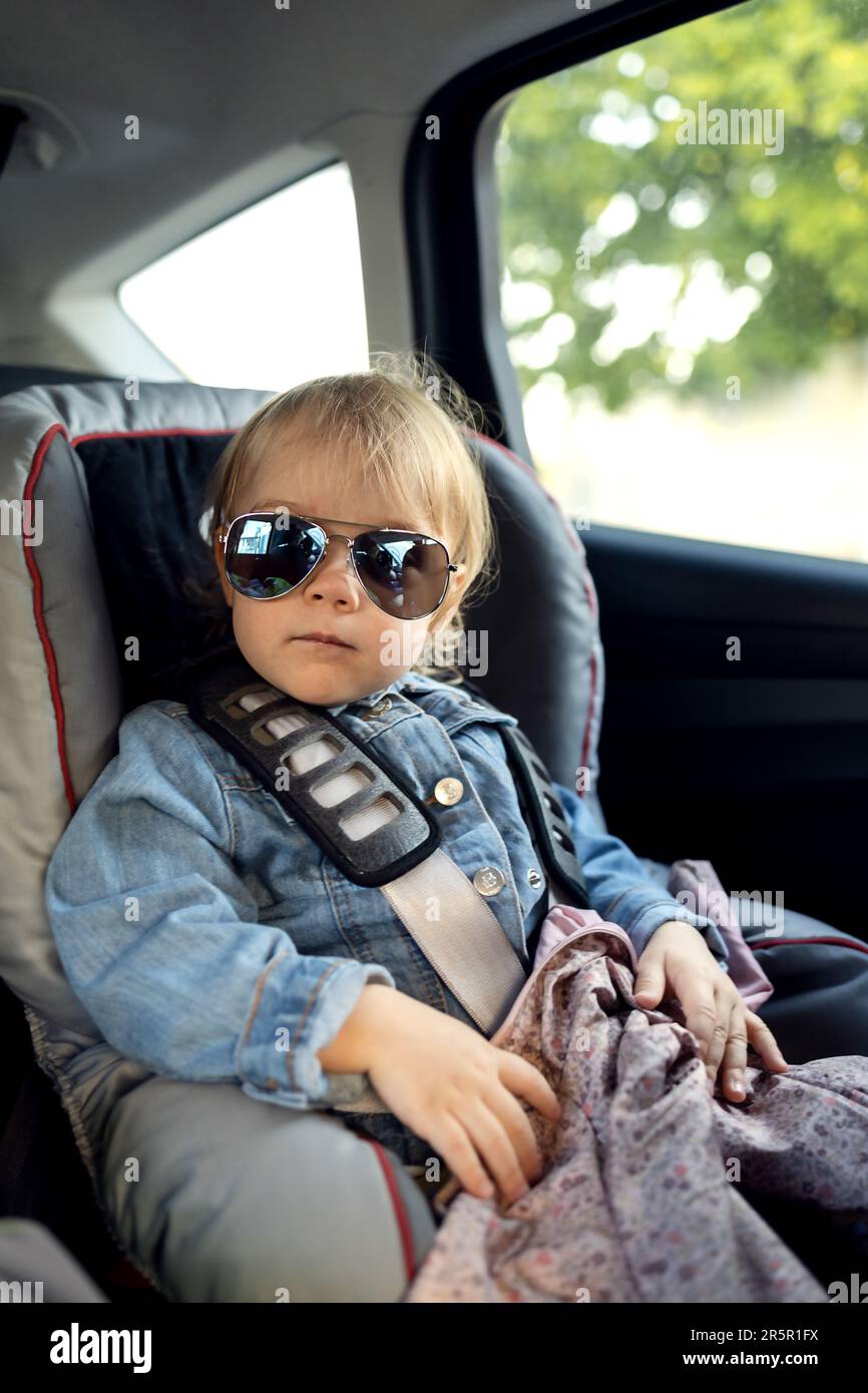 Das Baby sitzt in einem Kindersitz in Dads Auto und macht eine Reise Stockfoto