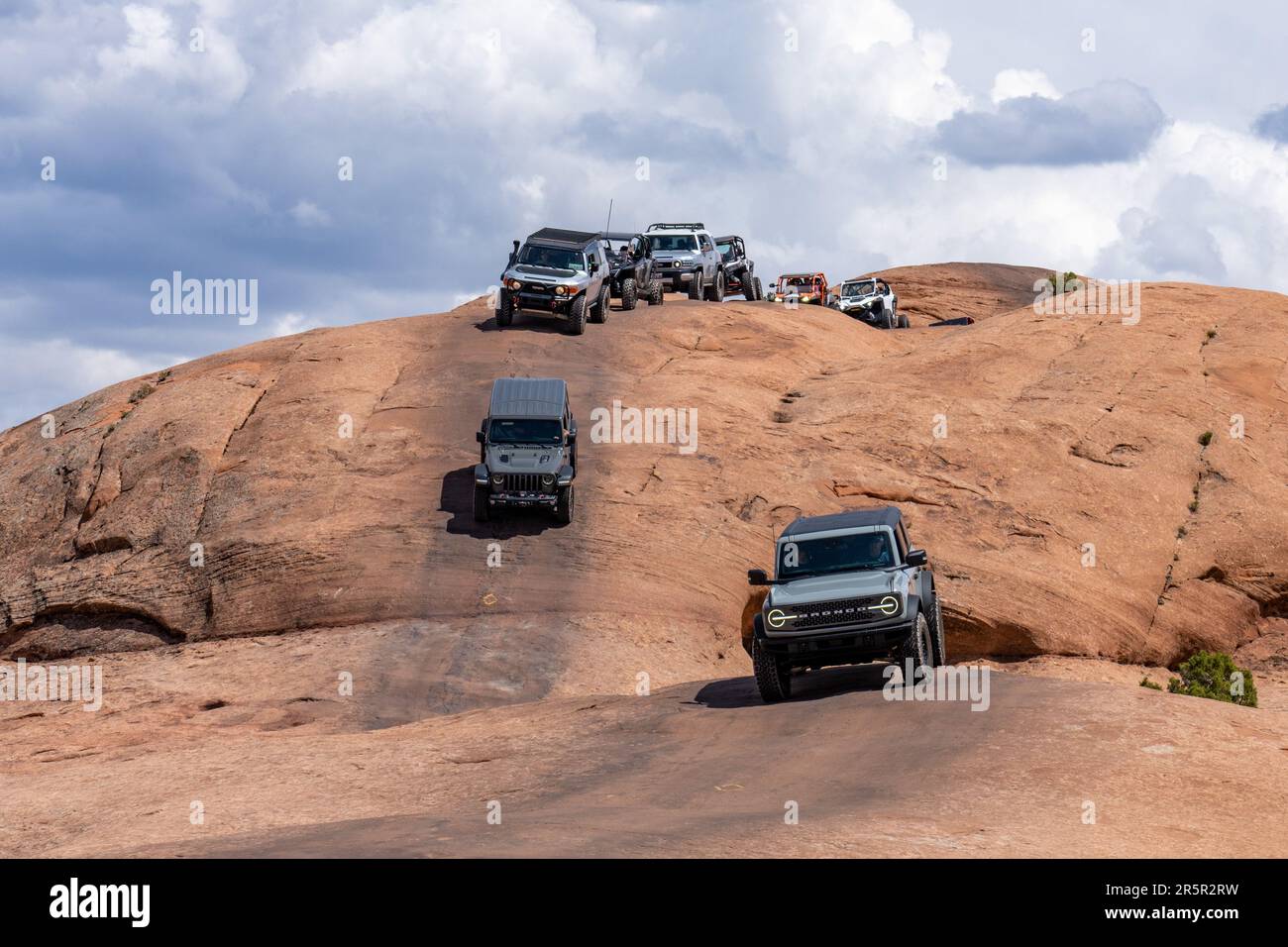 4WD SUVs und UTVs/OHVs auf dem Navajo Sandstein des Hell's Revenge OHV Trail in der Nähe von Moab, Utah. Stockfoto