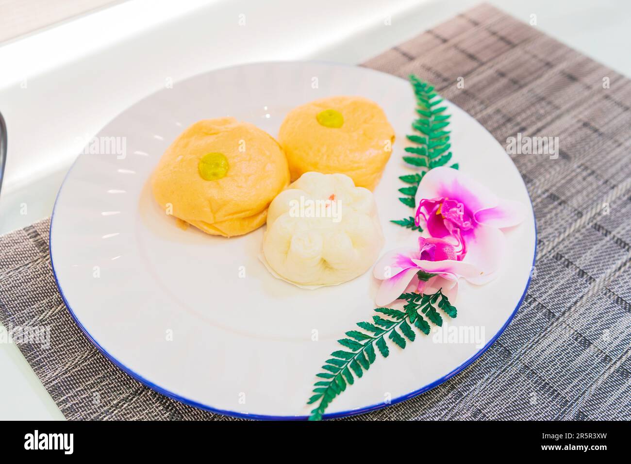 Genießen Sie die exquisite Schönheit gedämpfter Brötchen auf einer herrlichen Keramikplatte. Stockfoto