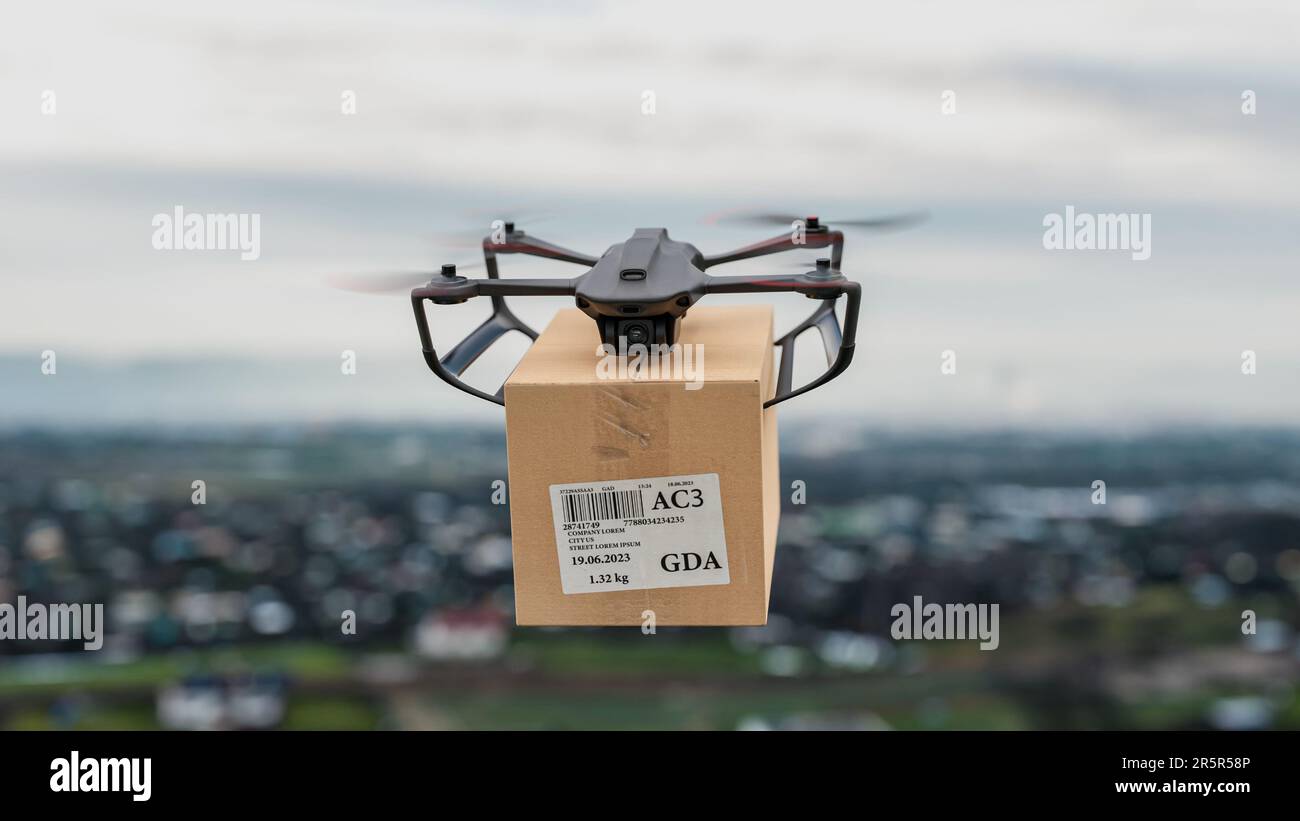 Die Drohne fliegt mit einem Paket für den Kunden über die Stadt – eine Nahaufnahme des Geräts, das Konzept der Drohnenlieferung. Stockfoto